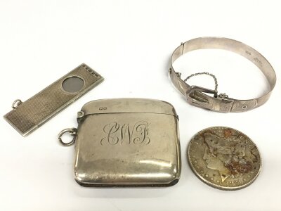 A mixed silver lot including a 1921 Morgan dollar, vesta, cigar cutter and a bangle. 120g total weight