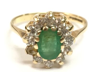 A 9ct gold oval cut green stone ring surrounded by white stones. Ring size M. 2.5g
