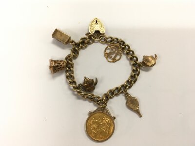 A 9ct gold charm bracelet with multiple charms and a 1905 Melbourne mint mark sovereign. 39.31g.