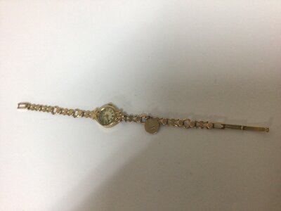 A Vintage Swiss made 9 carat gold ladies watch with an attached gold charm weight 12.5g