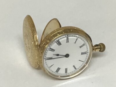 An 18carat gold cased Swiss button wind fob or small pocket watch seen working with a gold inner back and elaborate engraved case. Total weight 25g