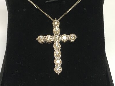 A 9ct white gold diamond cross with silver chain. Diamonds approximately 2.41ct