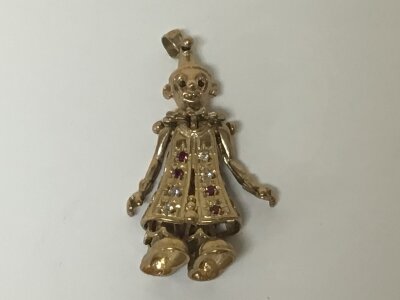 A 9cart gold charm in the form of a clown set with ruby coloured stones. Weight 6g
