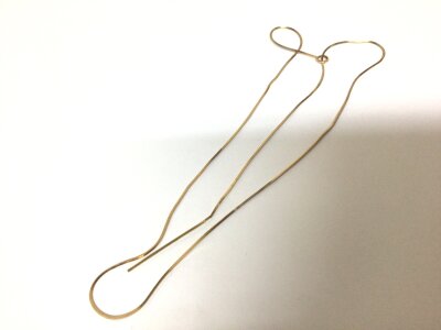 A modern design 9carat gold necklace with a vertical drop narrow rectangle pendant attached.