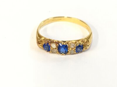 An 18ct gold ring set with stones. Size N and 2.31g