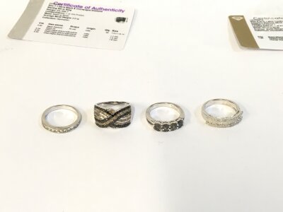 Four silver rings of assorted designs.