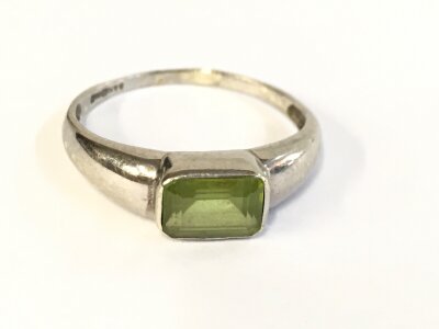A 9ct white gold ring set with a single green peridot. Size P and 1.92g