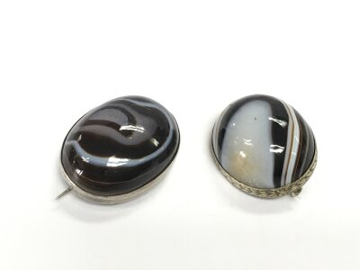Two banded agate and white metal brooches.