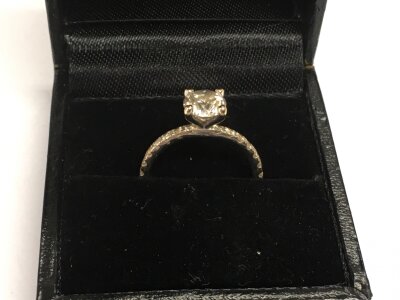An 18ct white gold and diamond solitaire ring, 85 pts RBC G/H with diamonds to the shoulders, approx 2.2g and approx size I-J.
