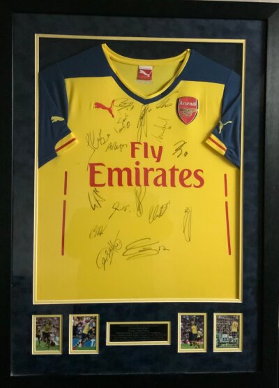 Arsenal 2015 FA Cup Winners Signed Framed Football Shirt: Stunning framed yellow short sleeve shirt with matching 28 x 39 inch frame. Genuine autographs with a few pictures of the team on the famous win over Aston Villa. Signatures x 16 include Ozil Wenger Ramsey Giroud and Flamini. Full list on plaque under shirt which is pictured online. Nice item with COA from reputable source.