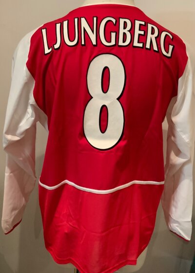 Arsenal Ljungberg Match Worn Football Shirt: Red home long sleeve Nike 02 number 8 shirt with Ljungberg to rear. Champions League badge to one arm. Worn v Auxerre on 22 10 2002. COA signed by player. Vapour rub still evident on front of shirt. Inner mesh cut out but evidence it was there.
