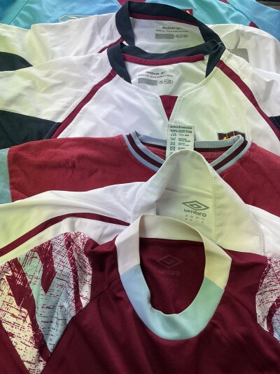 West Ham Football Shirt + Garment Collection: A selection of shirts, t shirts, track tops in various sizes and conditions. Must view as some shirts are retro remakes. (20)