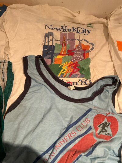 1980s New York Marathon Running Vests: A selection of t shirts to include an attractive 1985 New York skyline and Ellesse New York marathon plus  a 1983 made by Kappa. C/W New York Road Runners vest, 2 pairs of 1983 green shorts and a Mercedes marathon cap from unknown year a Boston Red Sox shirt and more.