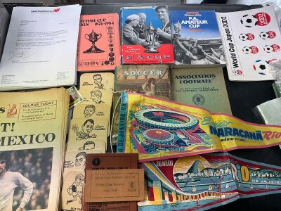 Football Memorabilia Box: Books on the history of the FA Cup, Amateur Cup, Scottish Cup, letters on club headed paper, World Cup 2002 memorabilia, Aston Villa early 60s beer mats and 58/59 season ticket,
, tea towels, Brazilian pennants, Mexico 1970 pre tournament newspapers, photos, Cardiff memorabilia including 2 x 1954 press photos v Peterborough, Irish Linen t towels, flags, cricket items and more. Instructions to sell.