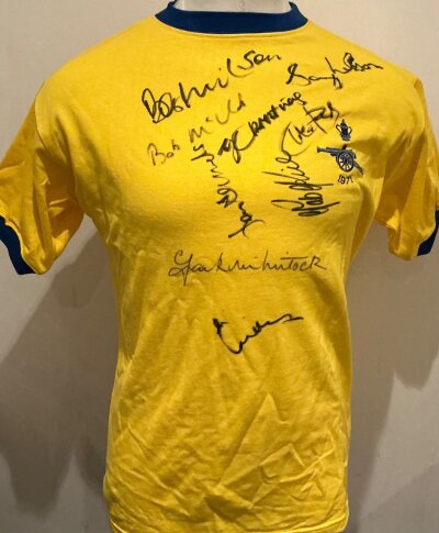 Arsenal 1971 FA Cup Final Signed Football Shirt: Yellow short sleeve shirt with 1971 emblem to breast. Signed by 9 players including McLintock Wilson McNab Nelson Sammels George Rice and Kennedy.