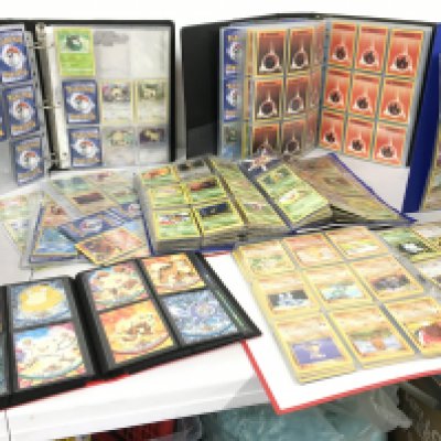 A collection of 7 album sets containing numerous Pokemon cards.