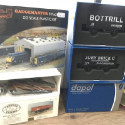 A collection of model railway pieces featuring 00gauge coaches by Oxford rail and a sealed 00 gauge Gaugemaster locomotive Depot kit in plastic. Plus 0 gauge wagons by Parkside Dundalk and Dapol. All boxed. No reserve