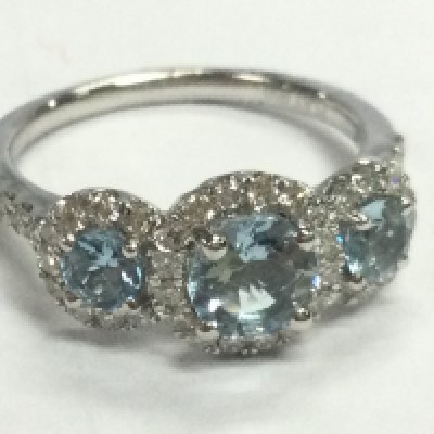 A platinum trilogy cluster ring set with three round aquamarines each surrounded by RBC diamonds, with diamond set shoulders, aquamarines 1.04ct , diamond 0.48ct . Ring Size O.