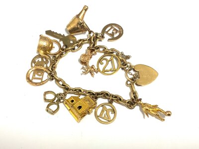 A 9ct gold charm bracelet with multiple attached 9ct gold charms. 33.1g.