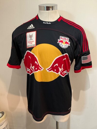 Thierry Henry Red Bull New York 2011 Match Worn Signed Football Shirt:  Black shirt with attractive red and yellow large red bull logo to front. MLS badge to one sleeve and Emirates Cup 2011 badging to front. In this conpetion Henry got to play against his former club Arsenal. Signed to number on rear.