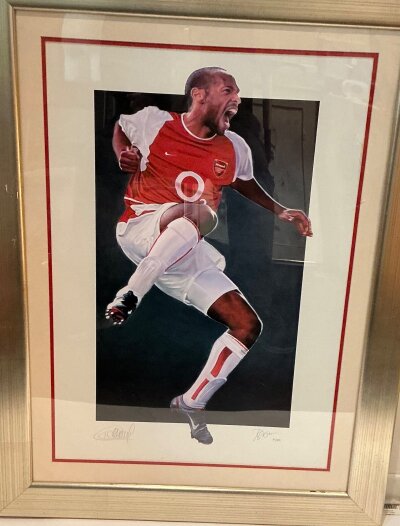 Thierry Henry Signed Framed Arsenal Football Print: Ltd edition print by Rob Highton signed by him and Henry. Ltd edition number 21/300 nicely framed and glazed measuring 89 x 68cm.