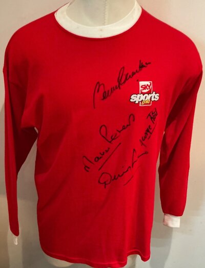Manchester United 1960S Signed Retro Football Shirt: Red long sleeve number 9 shirt signed to front by Best Law and Charlton of Man Utd plus Peters of West Ham. Sky Sports Gold badging to front.