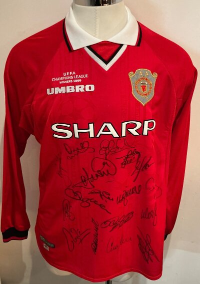 Manchester United Treble Season Football Shirt: Red long sleeve Sharp home shirt with UEFA Champions League Winners above Umbro to front. Signed to front by 17 with shirt map of autographs..
