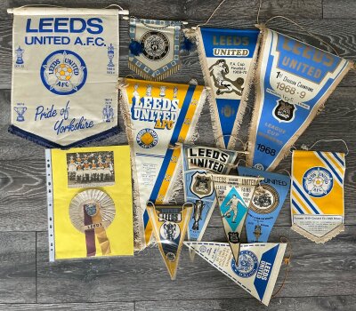 Leeds United Pennant Collection: 11 different pennants mainly from the great late 60s early 70s era in various sizes. Subjects include 68/69 League Winners, 1968 + 1971 Fairs Cup Winners, 69/70 FA Cup Finalists. C/W a 70s scarf with sewn on cloth badges and a rosette.