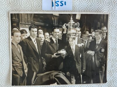 1951 Newcastle United FA Cup Winners Press Photo: Lovely 10 x 8 depicting the team at the station with the FA Cup after defeating Blackpool. Clearly original but previously stuck down so no stamp visible.