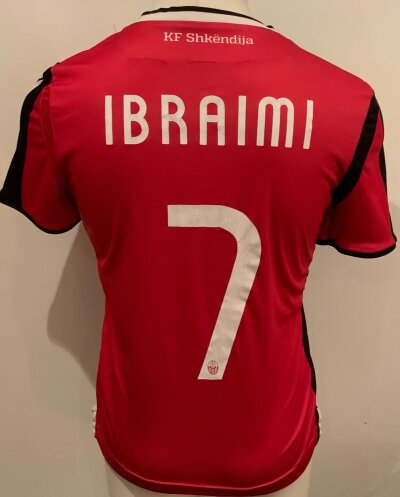 Shkendija 2020 - 2021 Match Worn Football Shirt: Europa League qualifier short sleeve red shirt with number 7 Ibraimi to rear. Worn v Tottenham. Some wear to lettering and stitching on neck.