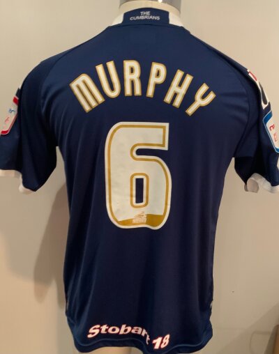 Carlisle United 2013 - 2014 Match Worn Football Shirt: Blue and red short sleeve shirt. Number 6 Murphy to rear. Match worn v Tottenham in the Carabao Cup.