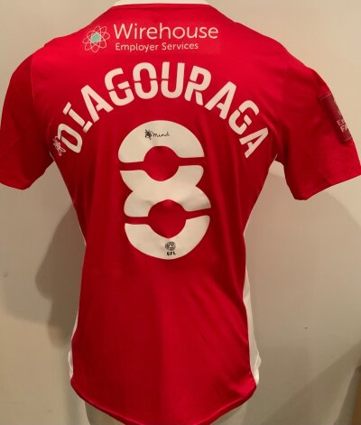Morecambe 2021 - 2022 Match Worn Football Shirt: Red short sleeve shirt. Number 8 Diagouraga to rear. Match worn v Tottenham in the FA Cup.