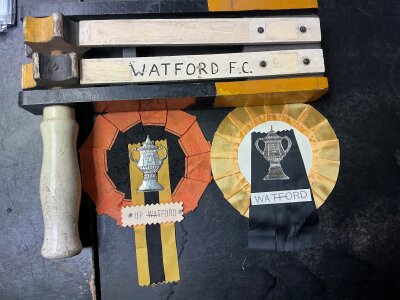 Watford Football Rattle + Rosettes: 1960s football rattle stating Watford FC and two different rosettes. Very good. (3)