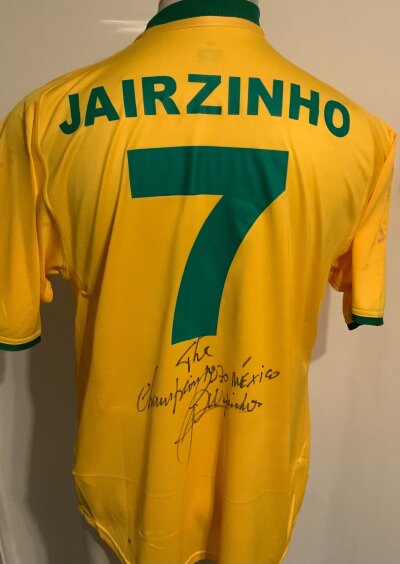 Brazil Jairzinho Signed Football Shirt: Yellow short sleeve shirt with rear having number 7 Jairzinho.. Signed to rear by him with the message The 1970 Champions Mexico. Few marks were possibly framed before.