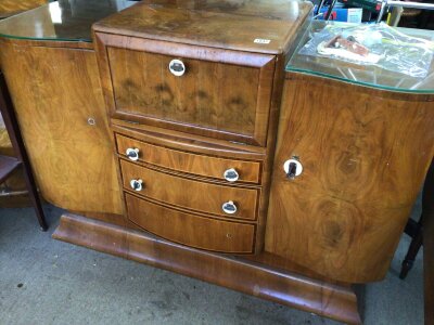 An Art Deco walnut Cocktail cabinet the hinged front and top enclosing a mirrored interior.above three graduating cross banded drawers sold with a bag of loose fittings. Length 138cm NO RESERVE