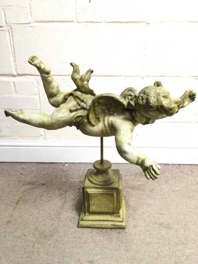 A composite cherub figure on stand, 59cm tall