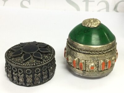 Two nickel silver or alpaca silver 800 snuff/ perfume / trinket boxes. 65mm high box with green stone lid and orange cabochon made from and similar 33mm high box. Velvet lied inside . Both marked on the bases 800. 3 and 6.5Cm tall