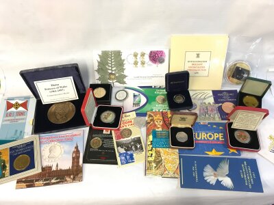 A collection of mixed uncirculated coin sets and other commemorative items including Titanic commemorative medal and 1982 and 1986 coin sets.