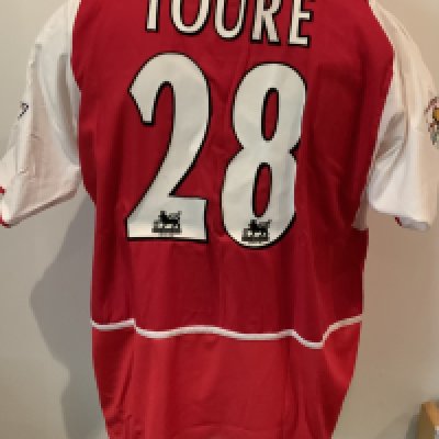 Arsenal Toure 2002 - 2003 Match Worn Home Football Shirt: Nike red short sleeve shirt with O2 sponsorship. Toure 28 to rear and Premier League Winners 2001/2002 sleeve badging. Inner mesh still attached. Some dirt marks to Sponsorship. Worn by Toure on 19 10 2002 with a COA signed by him.