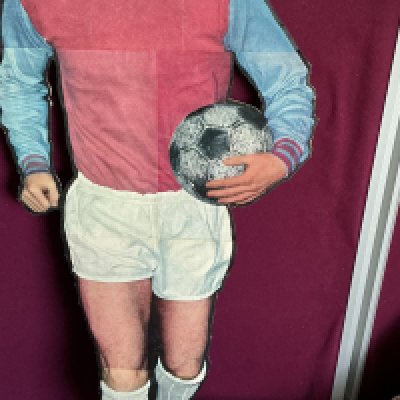Bobby Moore West Ham Large Cardboard Promotional Display: 42 inch high cardboard cut out of Bobby Moore in West Ham kit with the World Cup believed to be promoting a magazine in the 60s. C/W magazines and pictures of Bobby.