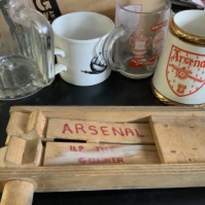 Arsenal Football Memorabilia Box: Includes 64/65 scrapbook, rattle, bed spread. puzzles, quantity of scarves, Irish Linen double team tea towel, mugs, posters, Panini Arsenal large photos in album with autographs to include Rocastle Adams Bould, large 88/89 champions + 1988 Littlewoods Cup flag and much more. Must view.
