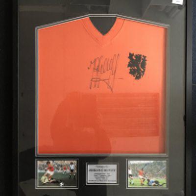 Johan Cruyff Signed Framed Holland Football Shirt: Netherlands replica 1974 World Cup shirt hand signed boldly by the 1974 World Cup player of the tournament. Nicely framed with two pictures of him in similar kit.