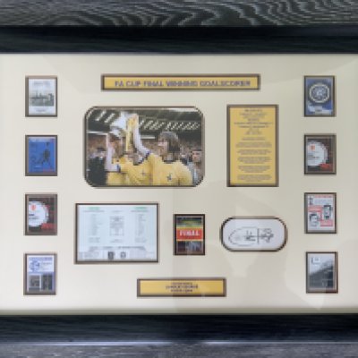 Arsenal 1971 FA Cup Final Signed Framed Football Display: A miniature reprint of the programme covers from every game in the FA Cup winning run. In this expensively framed montage is a picture of winning goalscorer Charlie George and also his autograph. Attractive piece measuring 31 x 24 inches. COA to rear.
