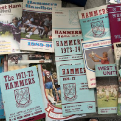West Ham Football Memorabilia Box: Books including a signed undedicated Billy Bonds, 2 signed Geoff Hurst photos including one by Autographed Editions, large quantity of fixture lists from the 70s onwards, 28 handbooks from 1958 - 2006 and more. (box)