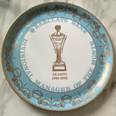 John Lyall Ipswich Town 91/92 Manager Of The Month Award: Aynesley China plate which states Barclays Bank Divisional Manager Of The Month. This was awarded for February 1992 in the season that Ipswich won league division 2. Photo included of Lyall with champagne and another in his office both signed by him. (Champagne not present)