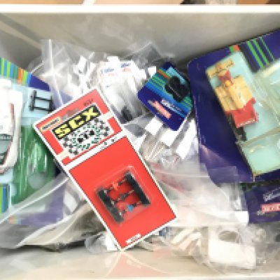 A Box Containing Many Scalextric Spate Parts. Including Motors Body's. Wheels. Etc.