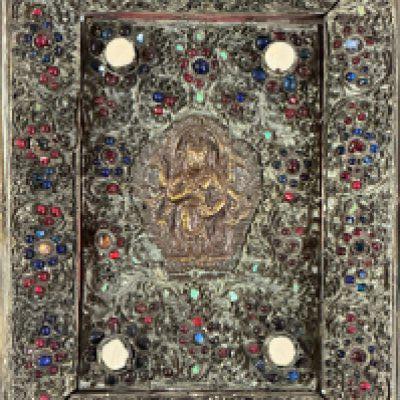 A Gilt Copper Votive Plaque Tibet / Nepal, Late 19th Century Centred by a seated Buddha on lotus base, with all over floral inlaid stone sprays, within a rectangular panel, and floral stone inlaid border. 20cm x 15.4cm. Prov. From the estate of Maharaja Bahadur of Burdwan" refered to as Sir Bijay Chand Mahtab , gifted to the vendors mother from the Maharaja of Burdwan in 1940 - (see attached gift card ). She said she'd admired it hanging on the wall at his Palace Residence - she first visited there early/mid 1930s. Whilst living, working near by and then married in India and became close to the Maharaja and his family until his death.