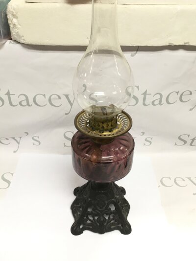 An oil lamp with a purple glass reservoir, approx height 54cm.