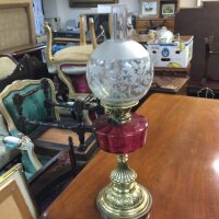 A late 19th century oil lamp with cranberry glass reservoir and brass base .66cm tall
