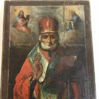 A 19th century Russian icon depicting Saint Nicholas of Myra , oil on wood, flanked by Christ and the mother of God with inscriptions 28.5cm wide 35cm tall approximately .